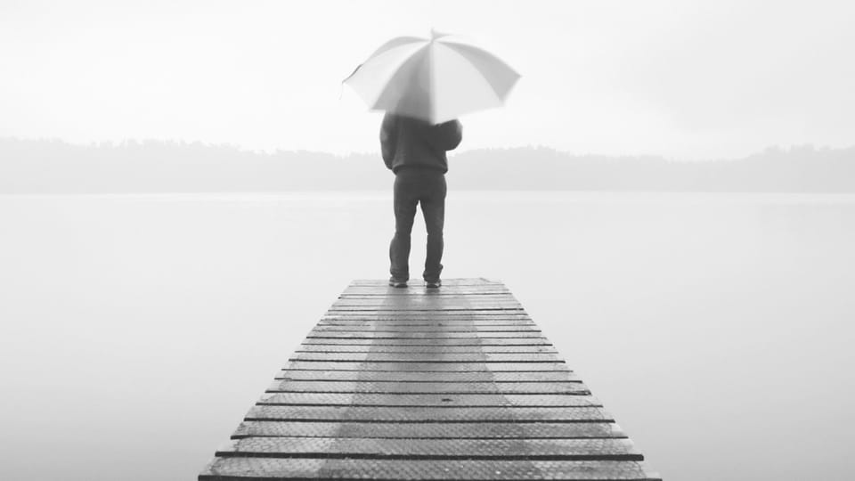 man on dock with umbrella